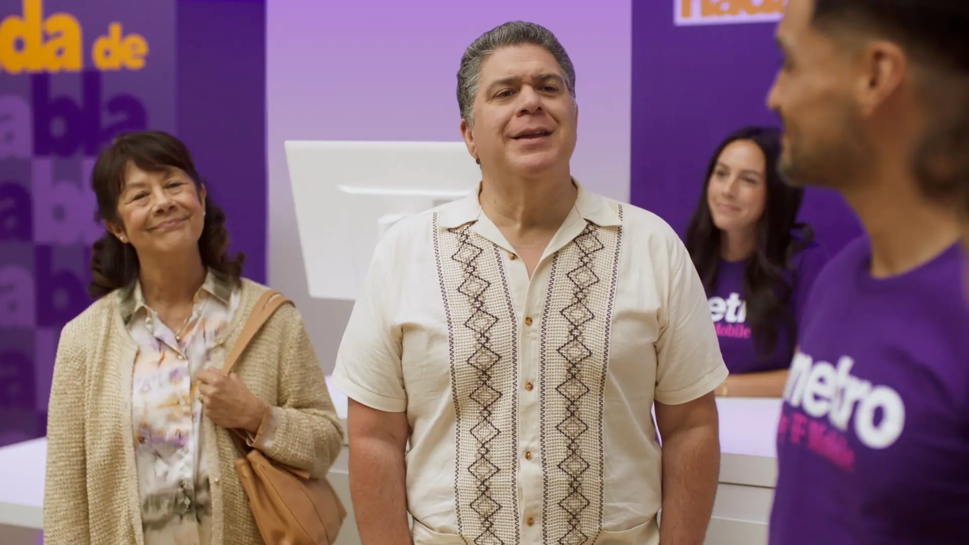 a couple asks questions of the staff at a Metro by T-Mobile store