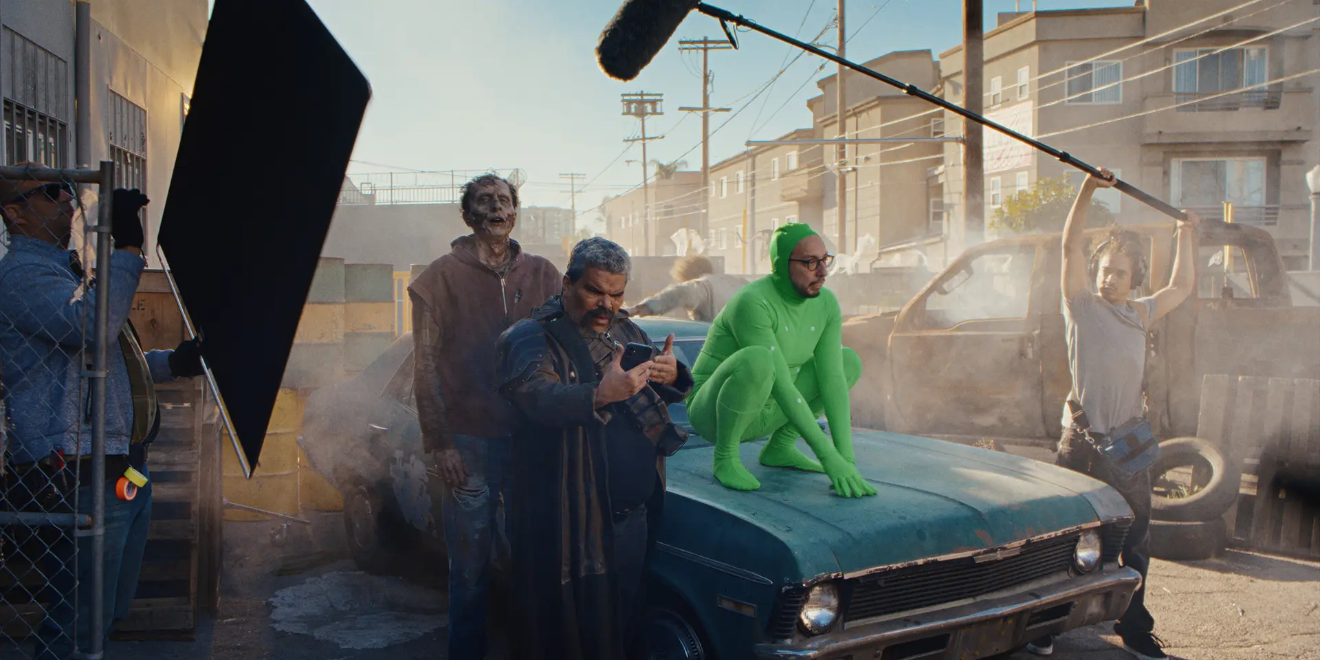 Luis Guzman looks confusedly at his phone while the production of a science-fiction movie comes to a halt around him