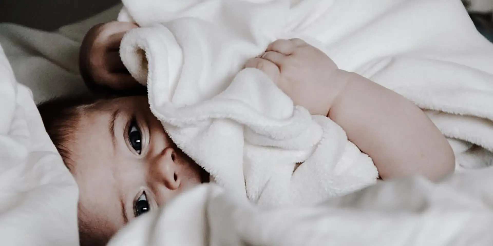 a baby wrapped in a fleece blanket