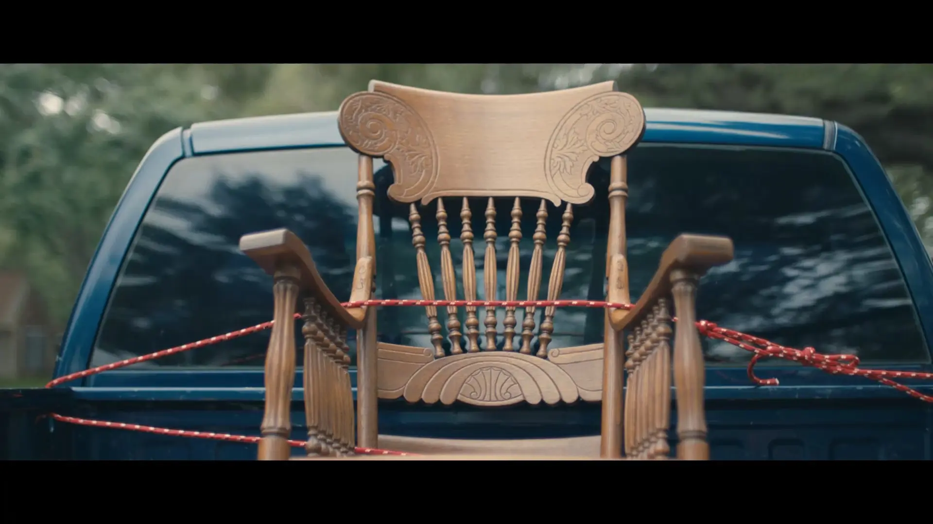 a rocking chair secure to the back of a pickup truck with bungee cables